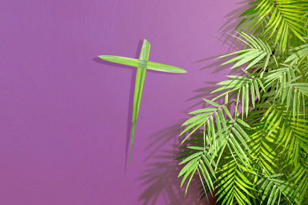 Palm leaf with a cross shape on a colored background. Palm Sunday Conceptの写真素材