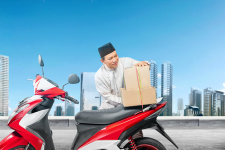 Asian Muslim man tying box on motorcycle prepare for mudik on the streetの写真素材