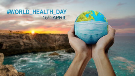 Human hand showing earth with a face mask. World Health Day Conceptの写真素材