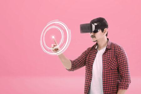 Asian man using a virtual reality device on a colored background