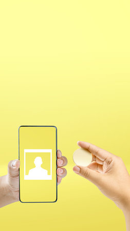 Human hand holding mobile phone screen with photo symbol on a colored backgroundの写真素材