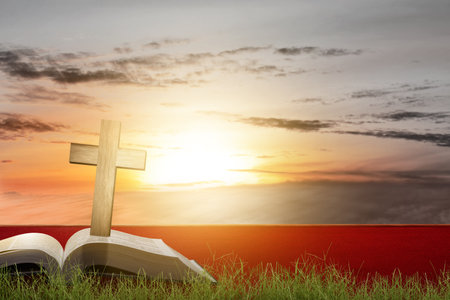 Christian Cross and open book with a sunset scene backgroundの写真素材