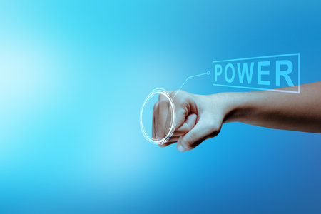 A human hand with the virtual screen with a power symbol on a colored backgroundの写真素材