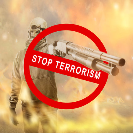 A man wearing a mask holding a gun with a stop terrorism sign with a fire backgroundの写真素材