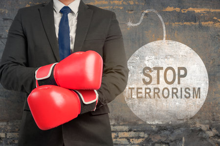 Businessman showing stop terrorism sign on the wallの写真素材