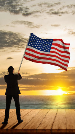Rear view of a businessman holding the American national flag. Memorial day conceptの写真素材