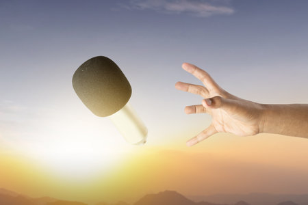 A human hand trying to reach a microphone. World press freedom day conceptの写真素材