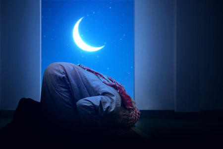 Muslim man with a beard wearing keffiyeh with agal in praying position (salat) on the prayer rug inside the mosqueの写真素材