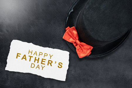 Black hat with a red bow tie on a colored background. Fathers day conceptの写真素材