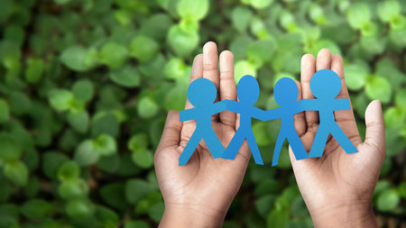 Human hand showing paper people are holding hands symbol of friendship. International friendship day conceptの写真素材