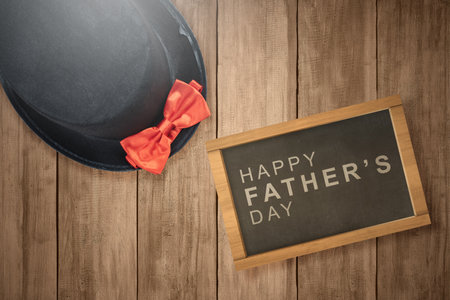 Black hat with a red bow tie on a wooden background. Fathers day conceptの写真素材