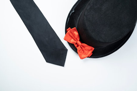 Black hat and black tie with red bow tie isolated over white background
