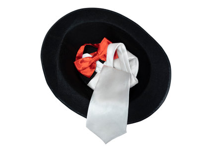 Black hat and silver tie with red bow tie isolated over white backgroundの写真素材