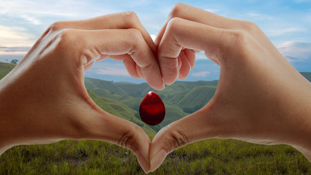 Human hand with heart shape showing red blood drop. World blood donor day conceptの写真素材