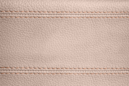 Close-up view of stitches with beige leather. Beige color backgroundの写真素材