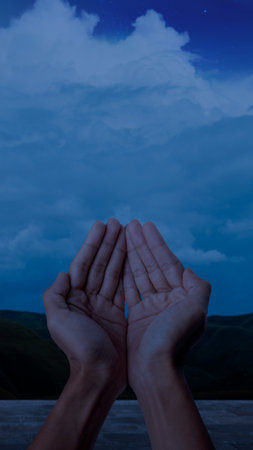 Muslim man raised hands and prayed with the night scene backgroundの写真素材