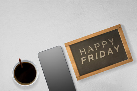 Mobile phone and coffee cup with a Happy Friday text. Happy Friday conceptの写真素材