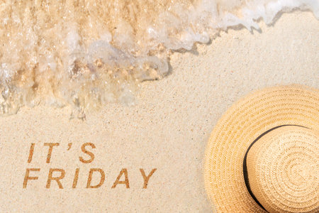 Hat on the sandy beach with It's Friday text. Happy Friday conceptの写真素材