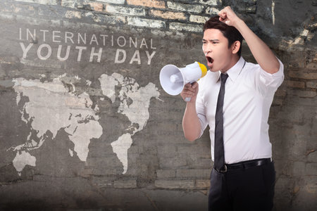 Businessman holding a megaphone shouting. International Youth Day conceptの写真素材
