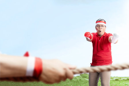 Indonesian man supporting the team when competing tug of war. Indonesian independence dayの写真素材