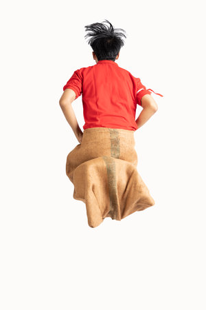 Indonesian men celebrate Indonesian independence day on 17 August with a sack race isolated over...
