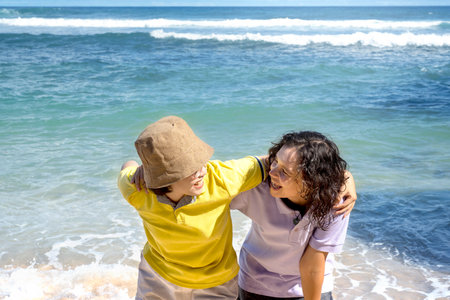 Two Asian women with an excited expression traveling on the beach with blue sky background