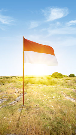 The red and white flag of Indonesian flag with the sunset scene backgroundの写真素材