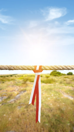 Ribbon with the red and white color of the Indonesian flag on ropes string with a blue sky background. Indonesian independence dayの写真素材