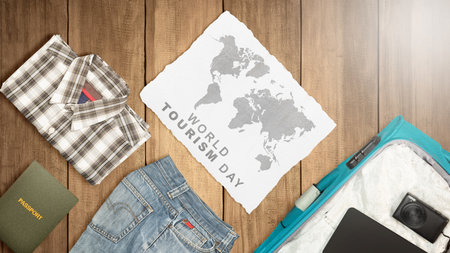 Clothes and suitcase with passport and camera on a wooden background. World tourism day concept