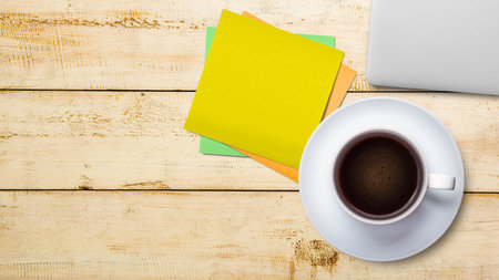 Cup of coffee with empty paper on wooden background. International coffee day conceptの写真素材