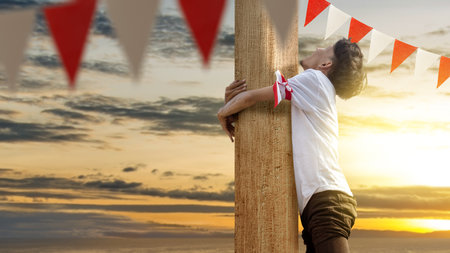 Indonesian men celebrate Indonesian independence day on 17 August with a climbing competition. Indonesian independence dayの写真素材