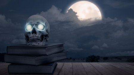 Stack of spell books with a human skull head with night scene background. Scary skull Halloween conceptの写真素材