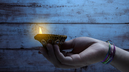 Woman hand holding Diya oil lamps for the Diwali festival. Diwali Festival. The Hindu Festival of...
