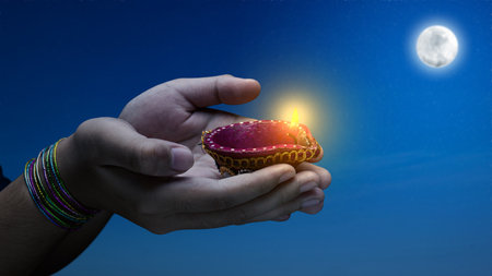 Woman hand holding Diya oil lamps for the Diwali festival. Diwali Festival. The Hindu Festival of...