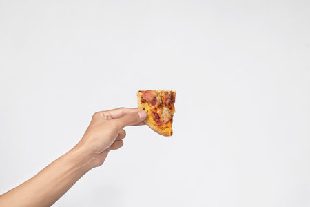 A human hand holding a slice of pizza with a white background