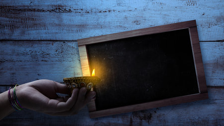Women hand holding Diya oil lamps for the Diwali festival with empty chalkboards for copy space. Diwali Festival. The Hindu Festival of Lights celebrationの写真素材