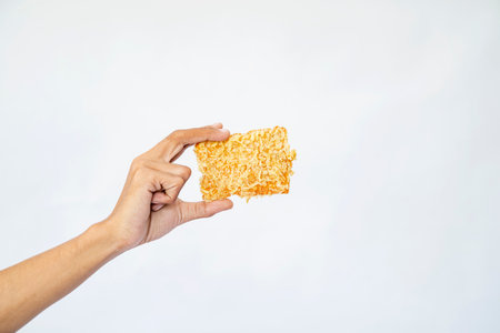 A human hand is holding a gorengan with a white background. Traditional Indonesia foodの写真素材