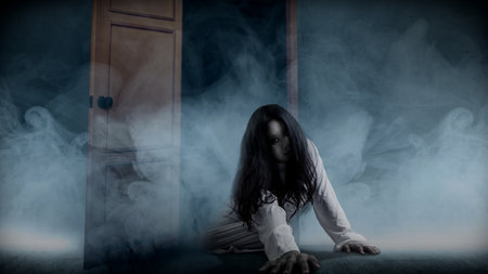 A scary ghost woman crawls on the floor with white smoke background. Scary woman. Halloween concept