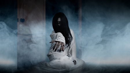 A scary ghost woman crawls on the floor with white smoke background. Scary woman. Halloween conceptの写真素材