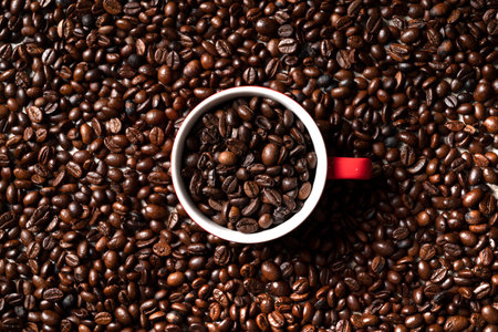 Glass with coffee beans on coffee beans background