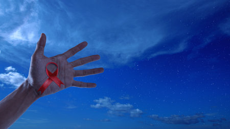 Human hand showing red ribbon awareness. World Aids Day concept