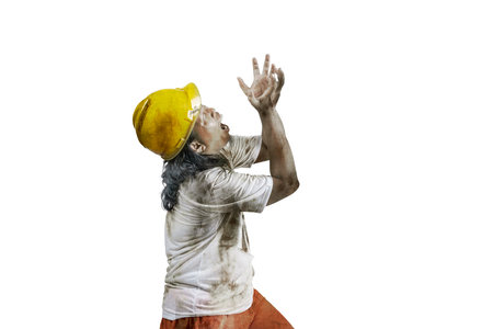 A scary construction worker zombie with blood and wounds on his body walking isolated over a white...