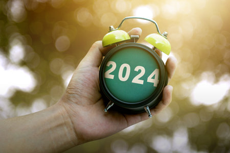 Human hand holding clock 2024. Happy New Year 2024