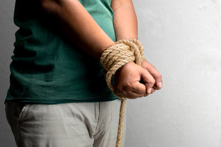 The man's hands are tied by rope. Violence conceptの写真素材