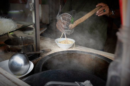 Waiter preparing chicken noodles (Mie Ayam) to serve. Traditional Indonesia food