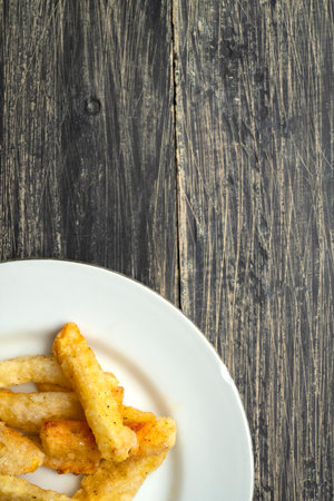 French fries on a plate on a wooden table