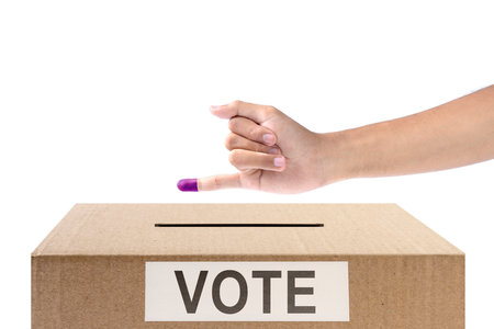 Human hand gesture after inserting vote paper into ballot box isolated over white background....