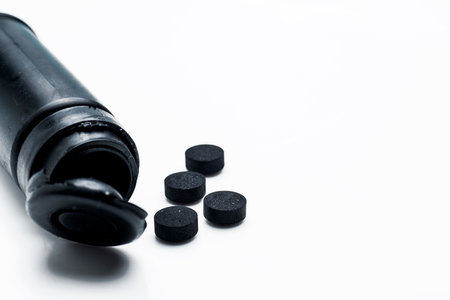 Pills spilled from the bottle isolated over a white background. Healthcare and medicine conceptの写真素材