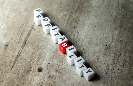 A row of small cubes with a profitability word. Financial concept