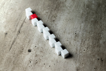 Zig-zag row of small cubes on a wooden tableの写真素材